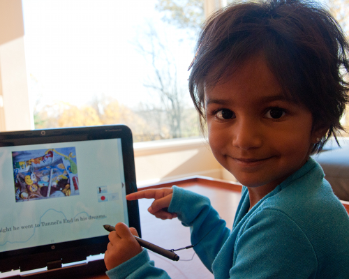 Young girl pointing at ReadN'Karaoke on a tablet